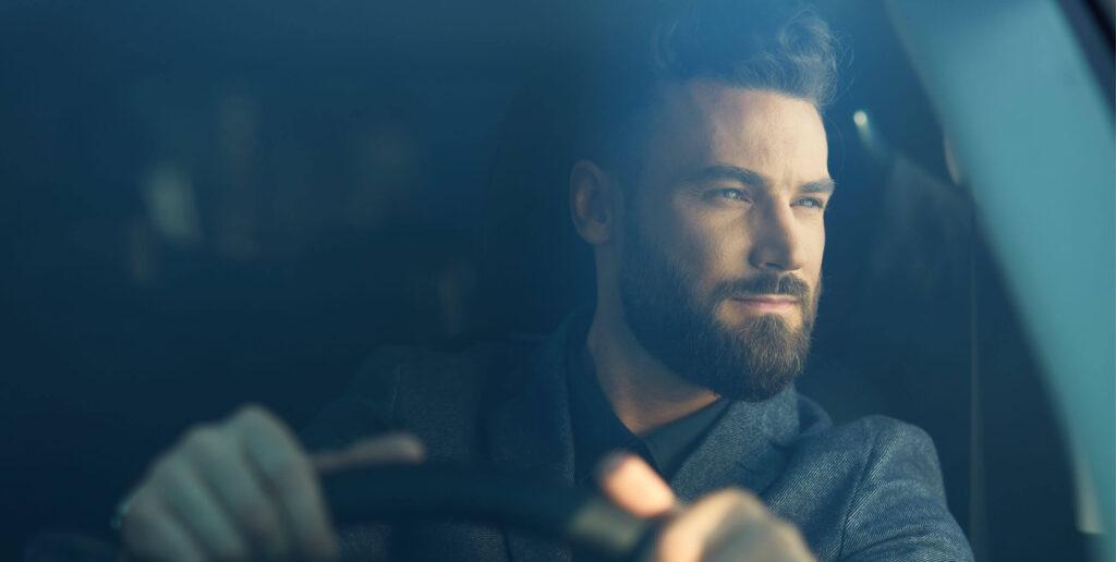 Man looking out car window while driving